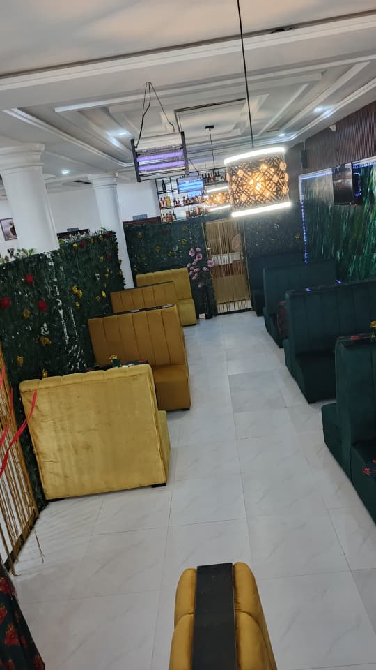 Bar seating area at Jogik with gold velvet couches and green leaf partitions