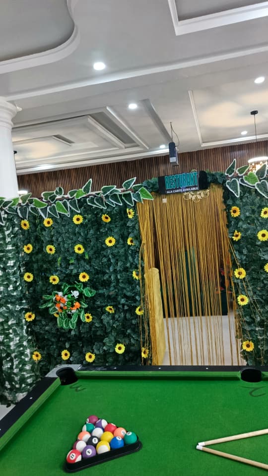 Jogik's à la carte dining entrance framed by a sunflower leaf wall and gold curtain