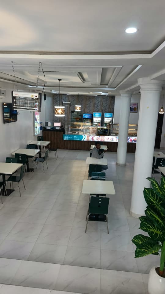 Main dining floor at Jogik with tables and the food counter in the background
