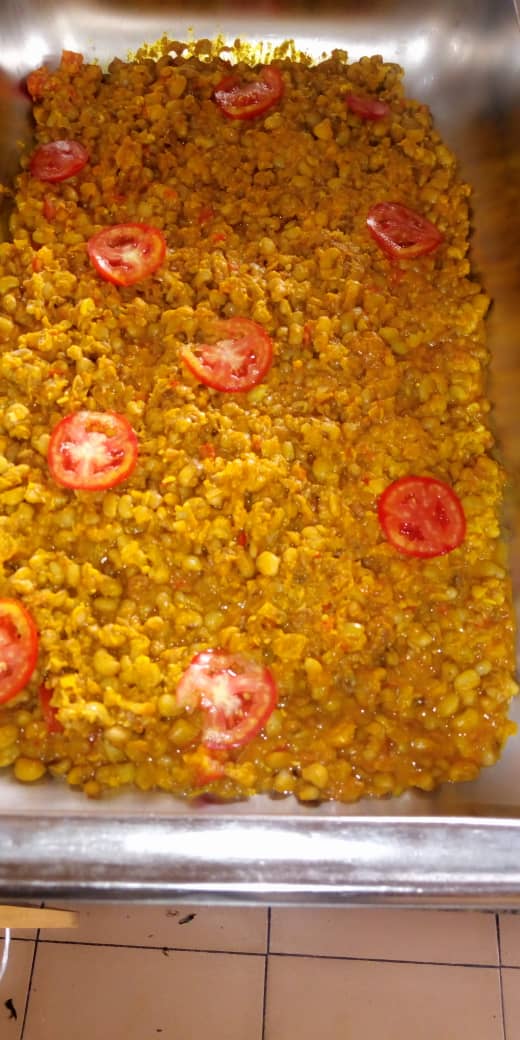 Tray of Jogik peppered beans cake topped with fresh tomatoes